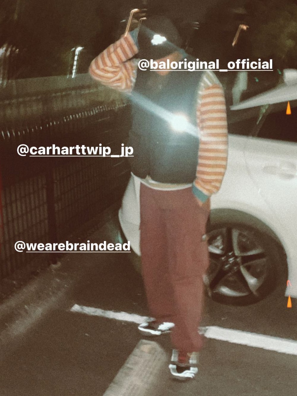 グレー系のスニーカー、レッド系のカーゴパンツ、ブラック系のベストを着用したメンズの夏コーディネートの1枚目の写真