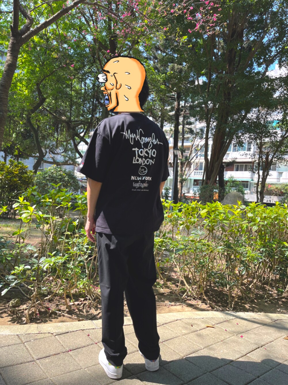ブラック系のTシャツ/カットソー、ブラック系のスラックス、ホワイト系のスニーカーを着用したメンズの春コーディネートの1枚目の写真