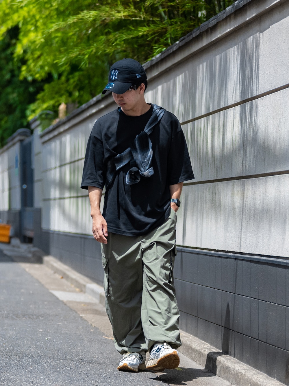 ブラック系のTシャツ/カットソー、グリーン系のカーゴパンツ、グリーン系のスニーカーを着用したメンズの夏コーディネートの1枚目の写真