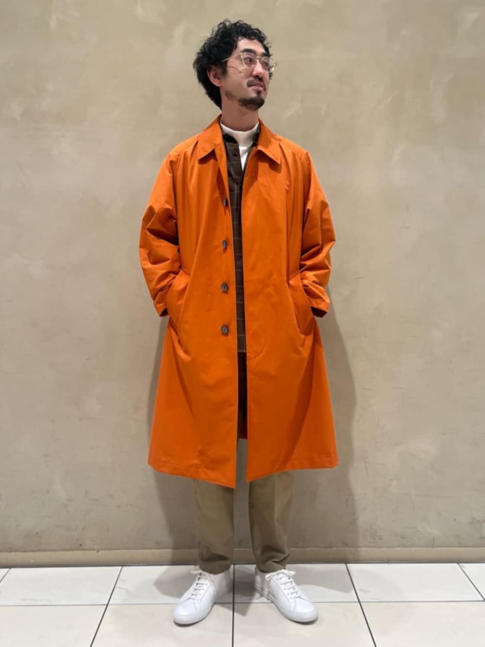 「TOMORROWLAND、トゥモローランド、common projects、ステンカラーコート、オレンジ、チェックシャツ、スニーカー、大人カジュアル、デイリーカジュアル」｜「TOMORROWLAND のコットンナイロンツイル ステンカラーコート（ステンカラーコート、オレンジ系）」を使った、Tsukinari_TOMORROWLANDさん（メンズ・175cm）の春コーディネートの1枚目の写真