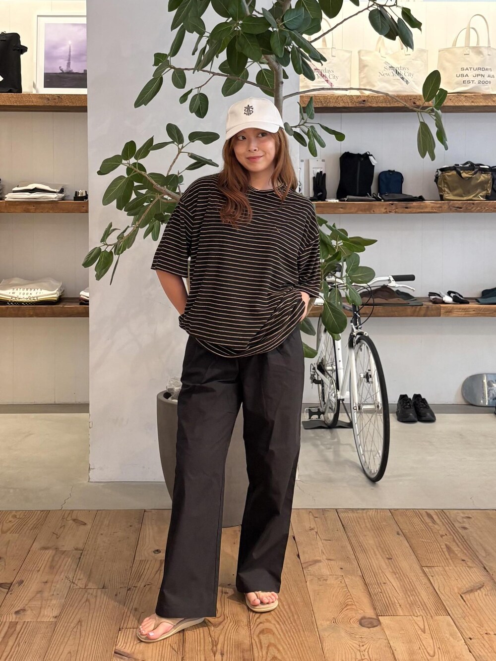ブラック系のその他パンツ、ブラウン系のTシャツ/カットソー、ホワイト系のキャップを着用したレディースの夏コーディネートの1枚目の写真