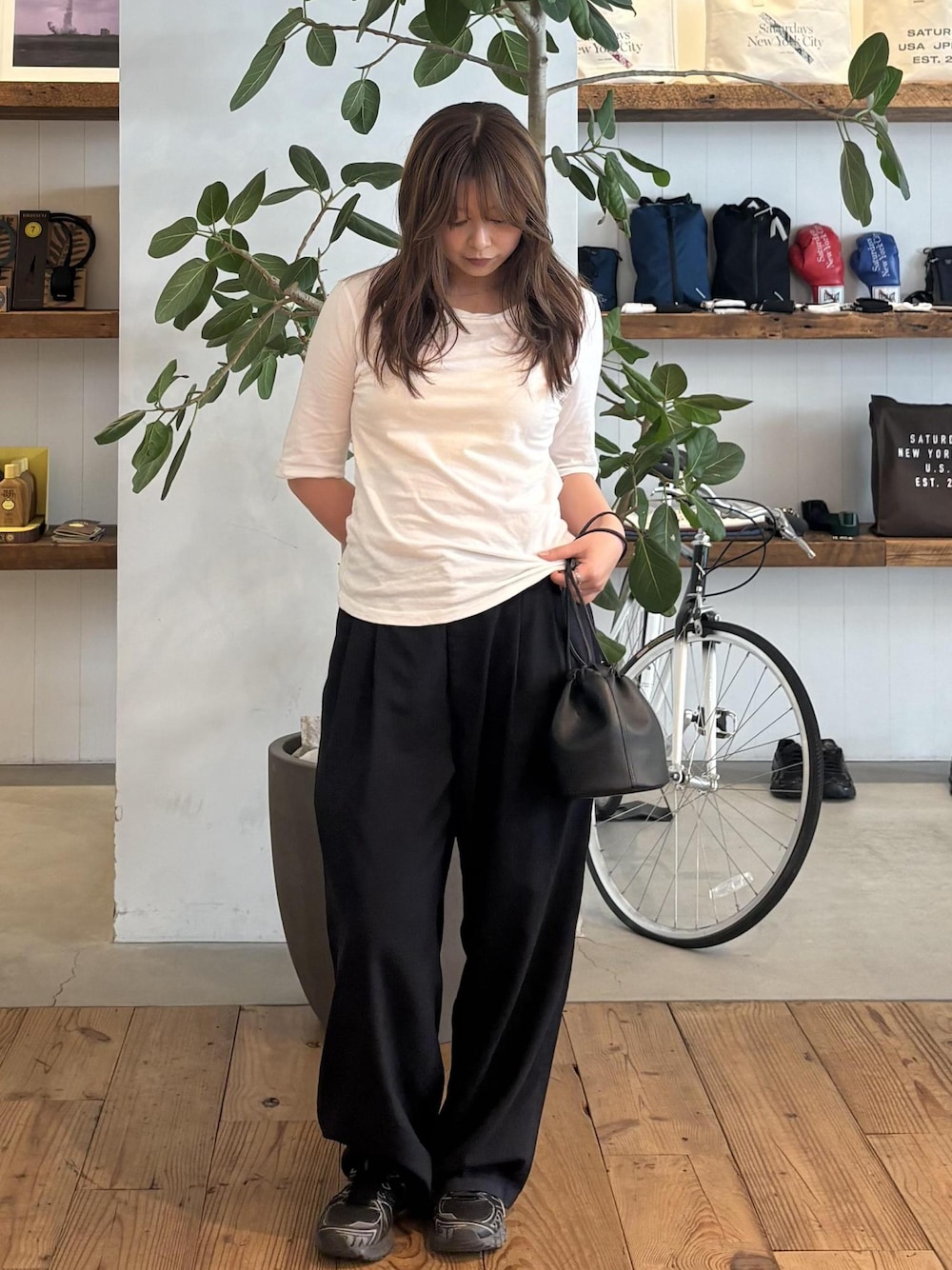 ブラック系のハンドバッグ、グレー系のTシャツ/カットソーを着用したレディースの春コーディネートの1枚目の写真