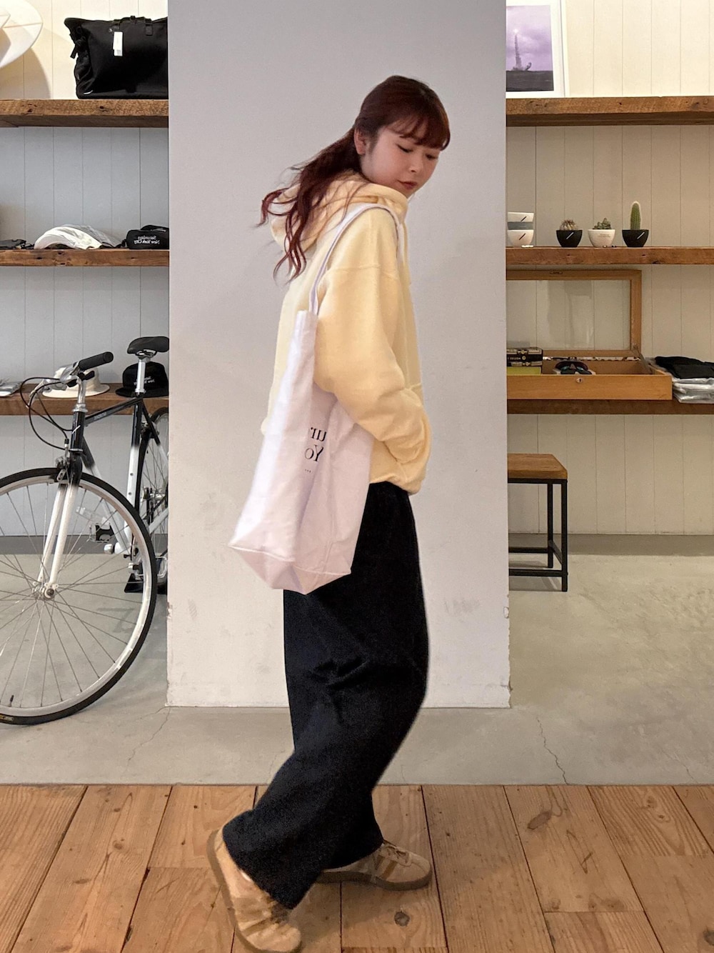 ベージュ系のパーカー、ホワイト系のトートバッグ、ブルー系のその他パンツを着用したレディースの春コーディネートの1枚目の写真