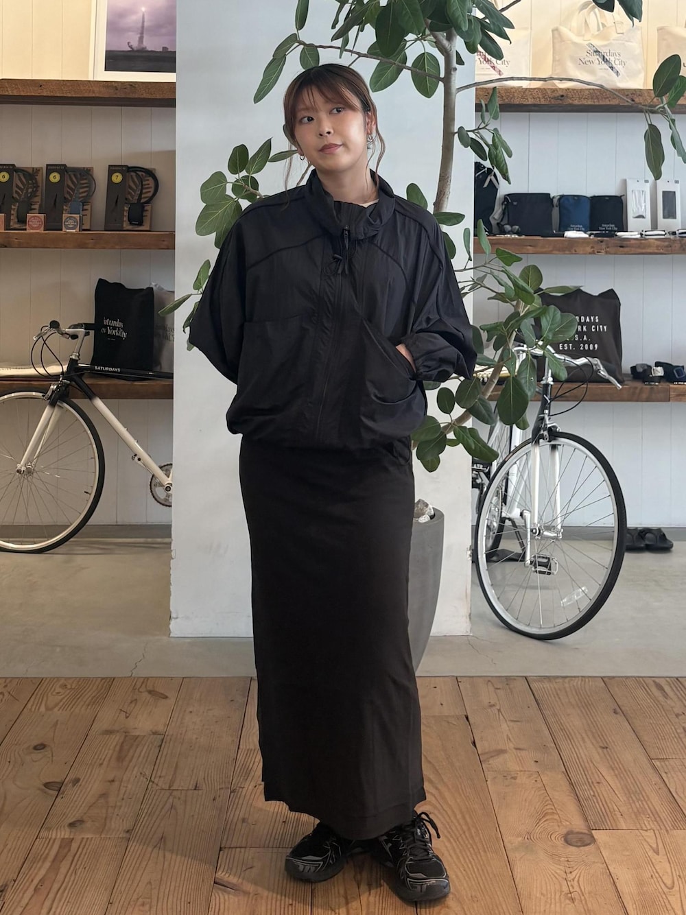 ブラック系のスカート、ブラック系のブルゾン、ホワイト系のTシャツ/カットソーを着用したレディースの春コーディネートの1枚目の写真