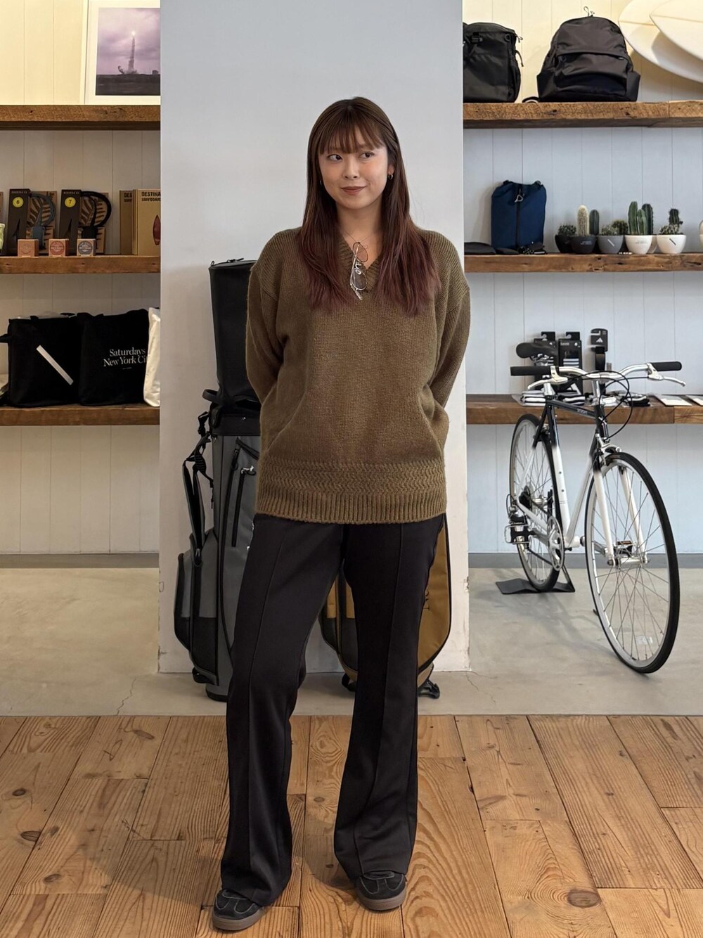 グリーン系のニット/セーター、ブラック系のキャップを着用したレディースの秋コーディネートの1枚目の写真