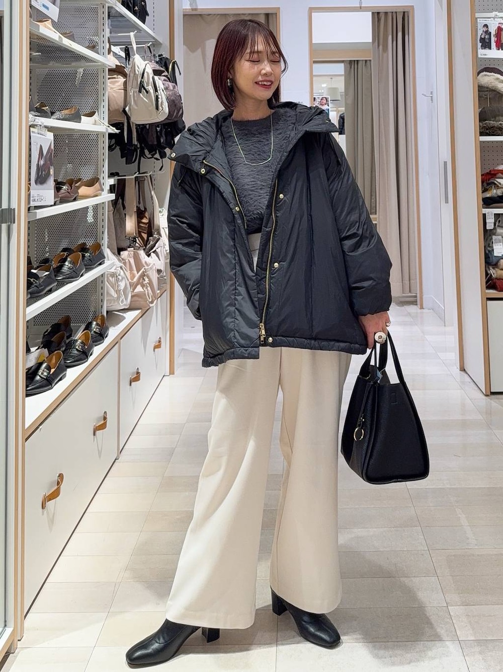 ブラック系のダウンジャケット/コート、ブラック系のトートバッグ、グレー系のその他パンツを着用したレディースの冬コーディネートの1枚目の写真