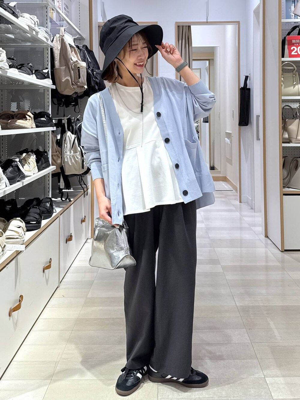 シルバー系のショルダーバッグ、ブルー系のカーディガン/ボレロ、ホワイト系のTシャツ/カットソーを着用したレディースの春コーディネートの1枚目の写真