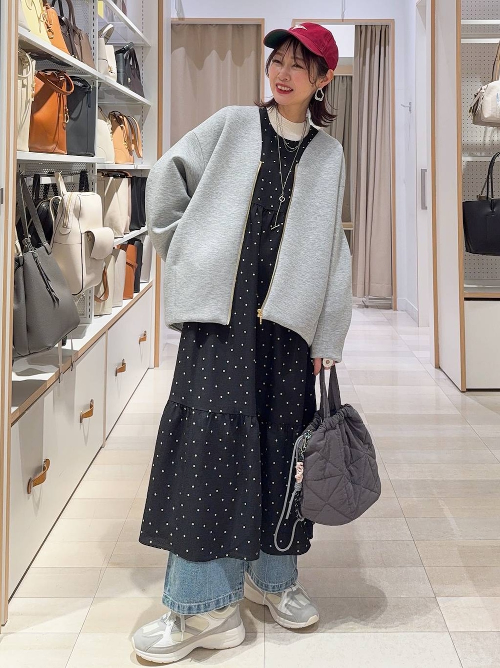 ホワイト系のスニーカー、ブルー系のデニムパンツ、ホワイト系のニット/セーターを着用したレディースの冬コーディネートの1枚目の写真