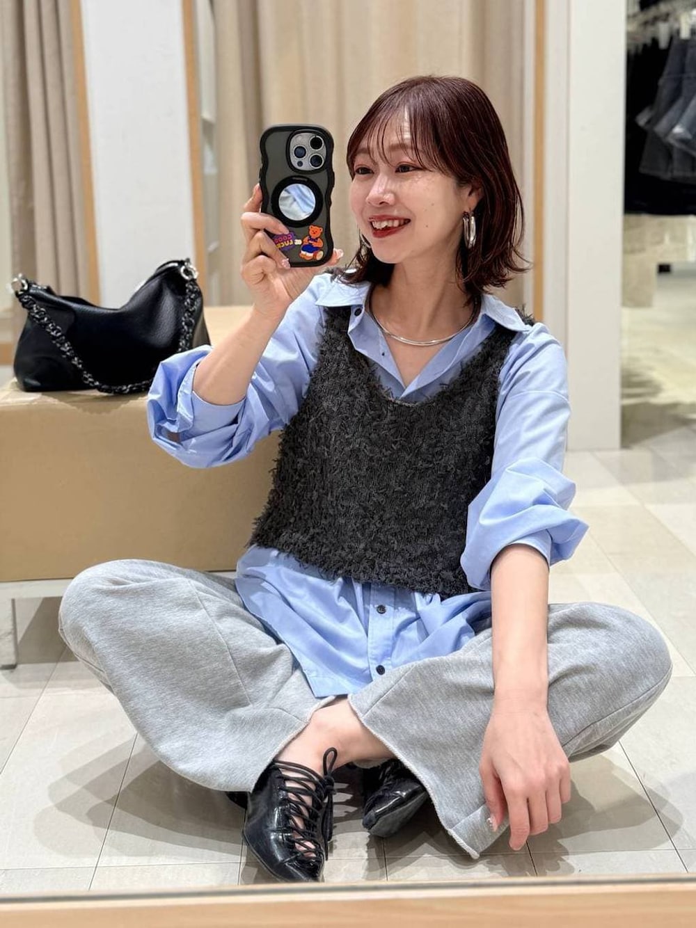 ブルー系のシャツ/ブラウス、グレー系のスウェットパンツ、グレー系のベストを着用したレディースの冬コーディネートの1枚目の写真