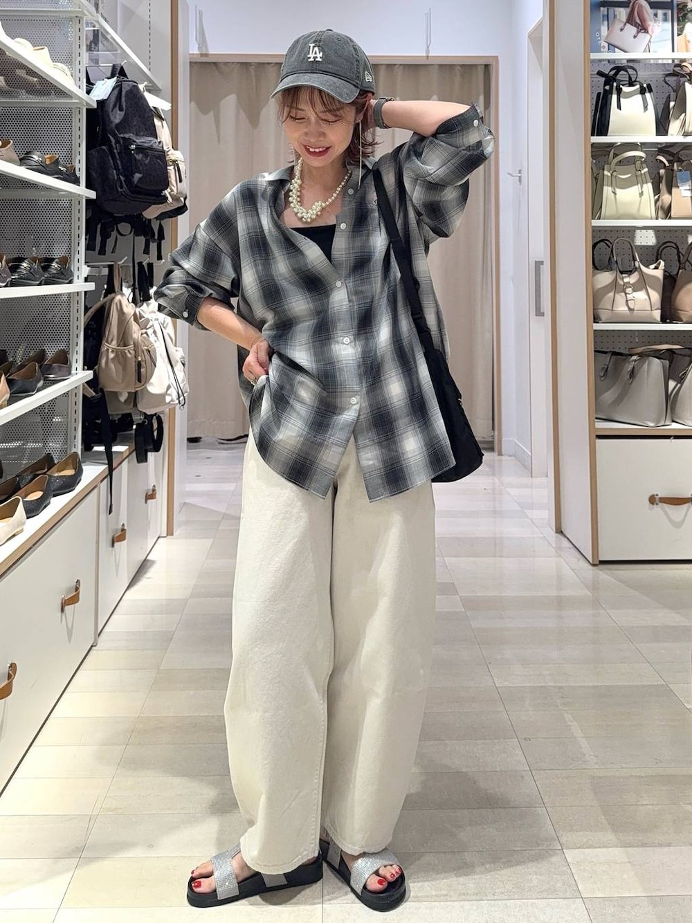 ホワイト系のデニムパンツ、ブラック系のキャミソール、ブラック系のシャツ/ブラウスを着用したレディースの夏コーディネートの1枚目の写真