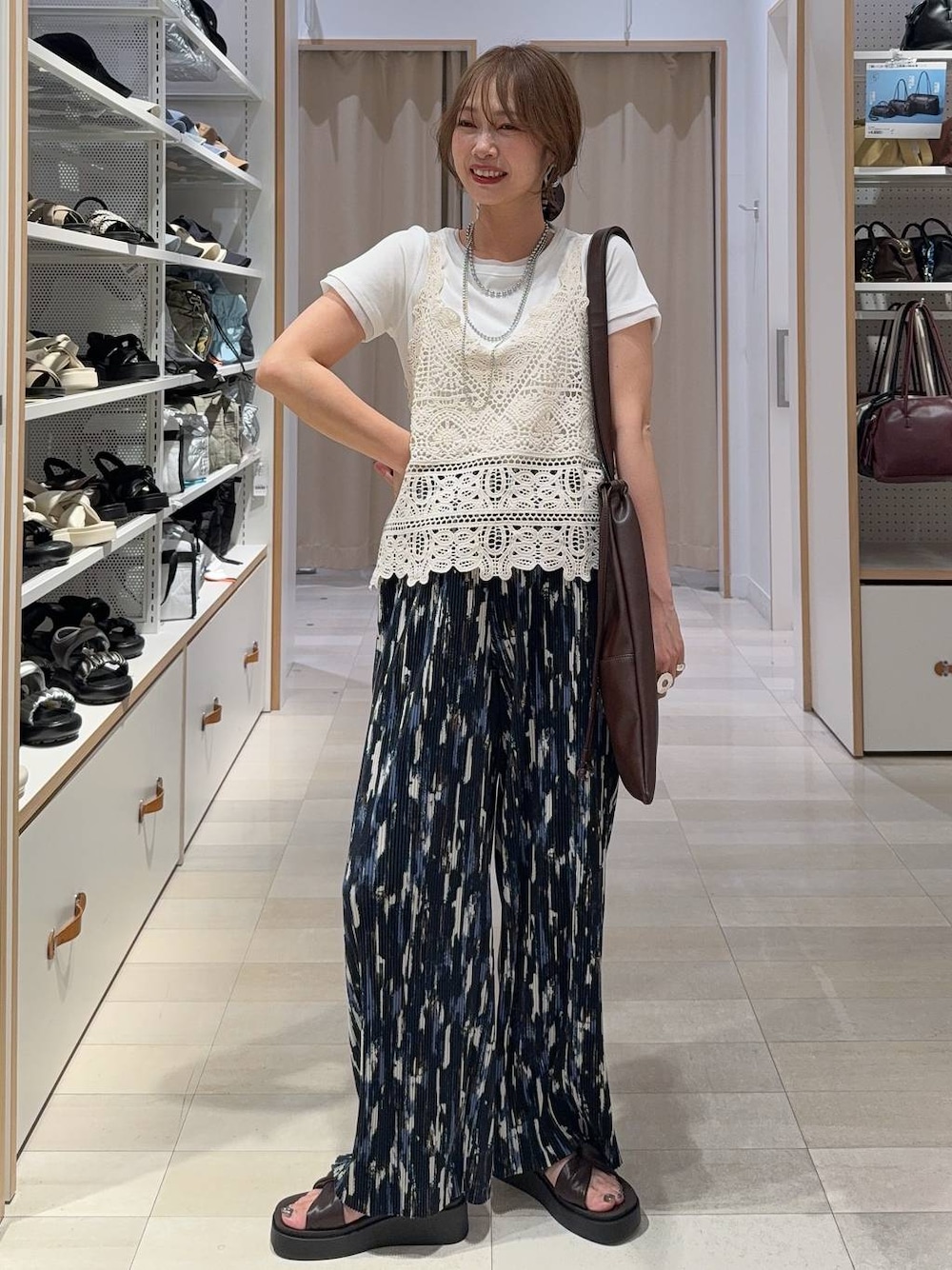 ブルー系のその他パンツ、ホワイト系のTシャツ/カットソー、ブラウン系のサンダルを着用したレディースの夏コーディネートの1枚目の写真