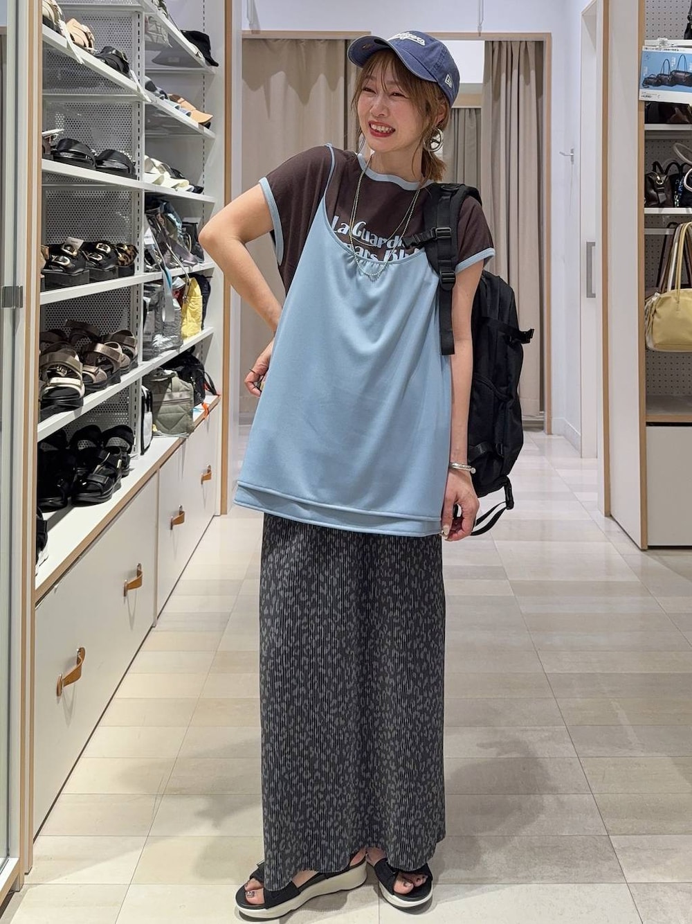 ブラック系のサンダル、ブラウン系のTシャツ/カットソー、シルバー系のネックレスを着用したレディースの春コーディネートの1枚目の写真