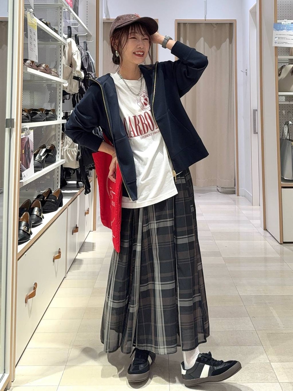 ブラック系のスニーカー、ブラック系のスカート、ホワイト系のTシャツ/カットソーを着用したレディースの秋コーディネートの1枚目の写真