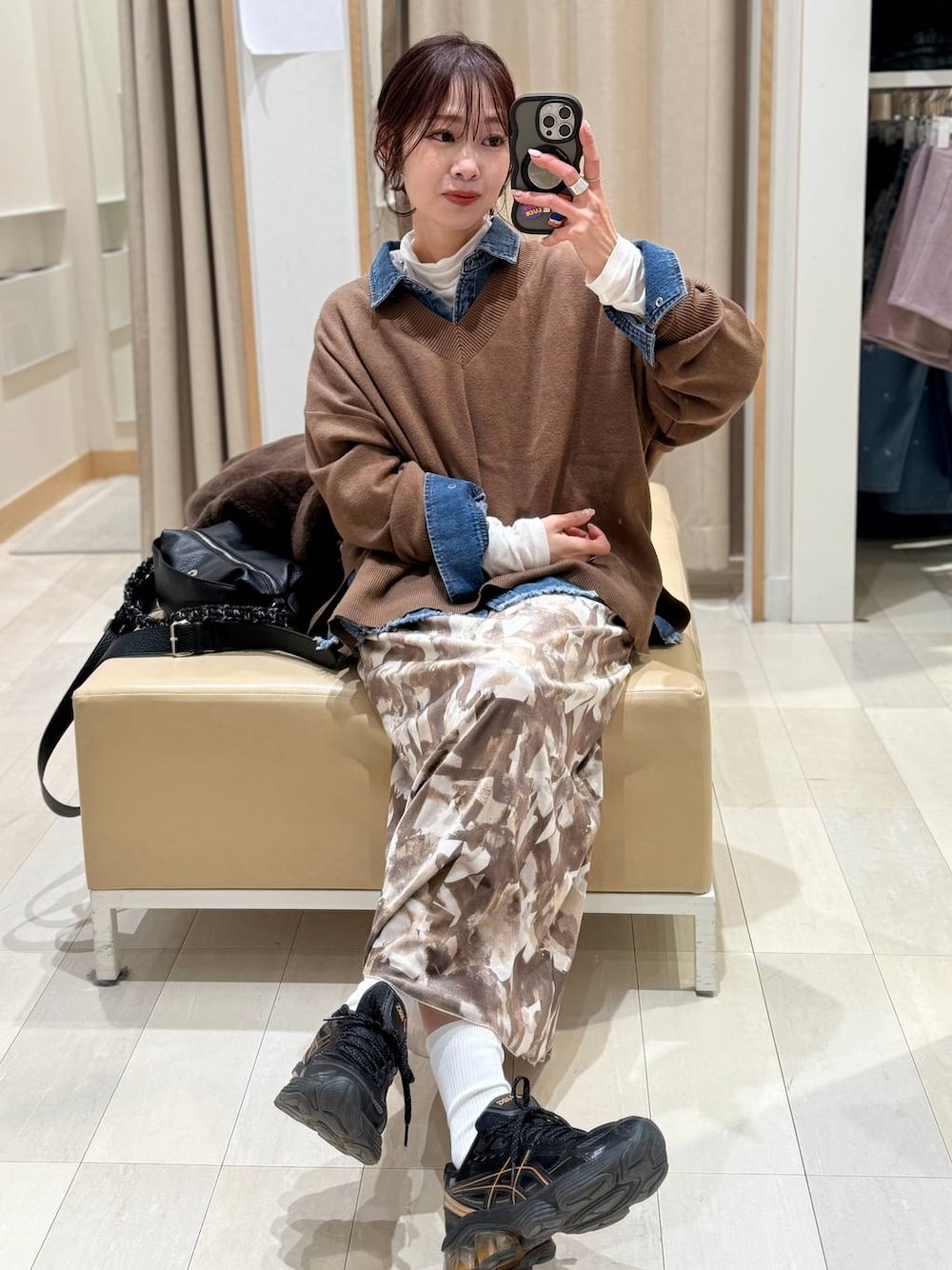 ブラウン系のニット/セーター、ホワイト系のTシャツ/カットソー、ブルー系のシャツ/ブラウスを着用したレディースの冬コーディネートの1枚目の写真