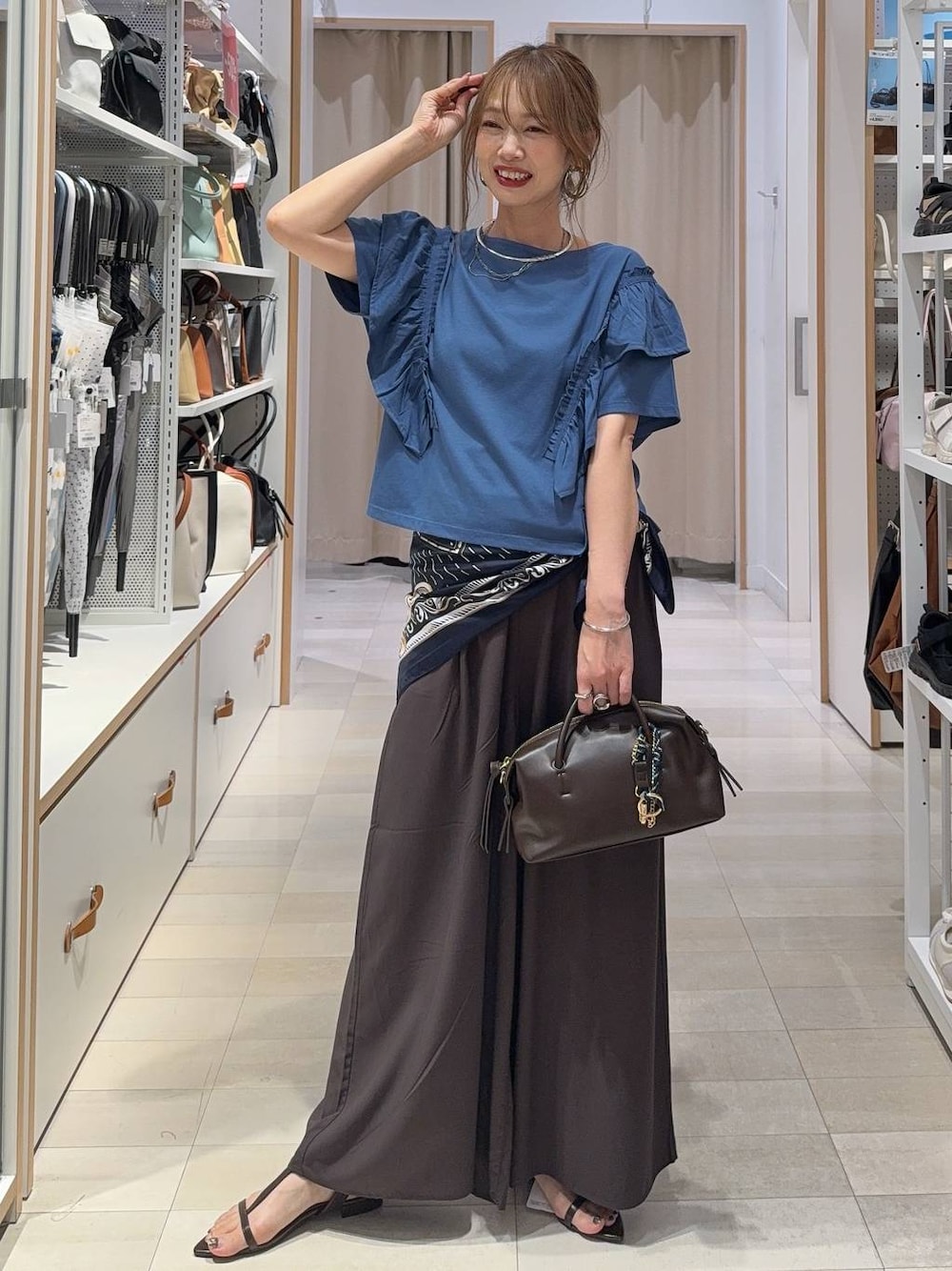 ブラウン系のその他パンツ、ブラウン系のボストンバッグ、ブルー系のTシャツ/カットソーを着用したレディースの夏コーディネートの1枚目の写真
