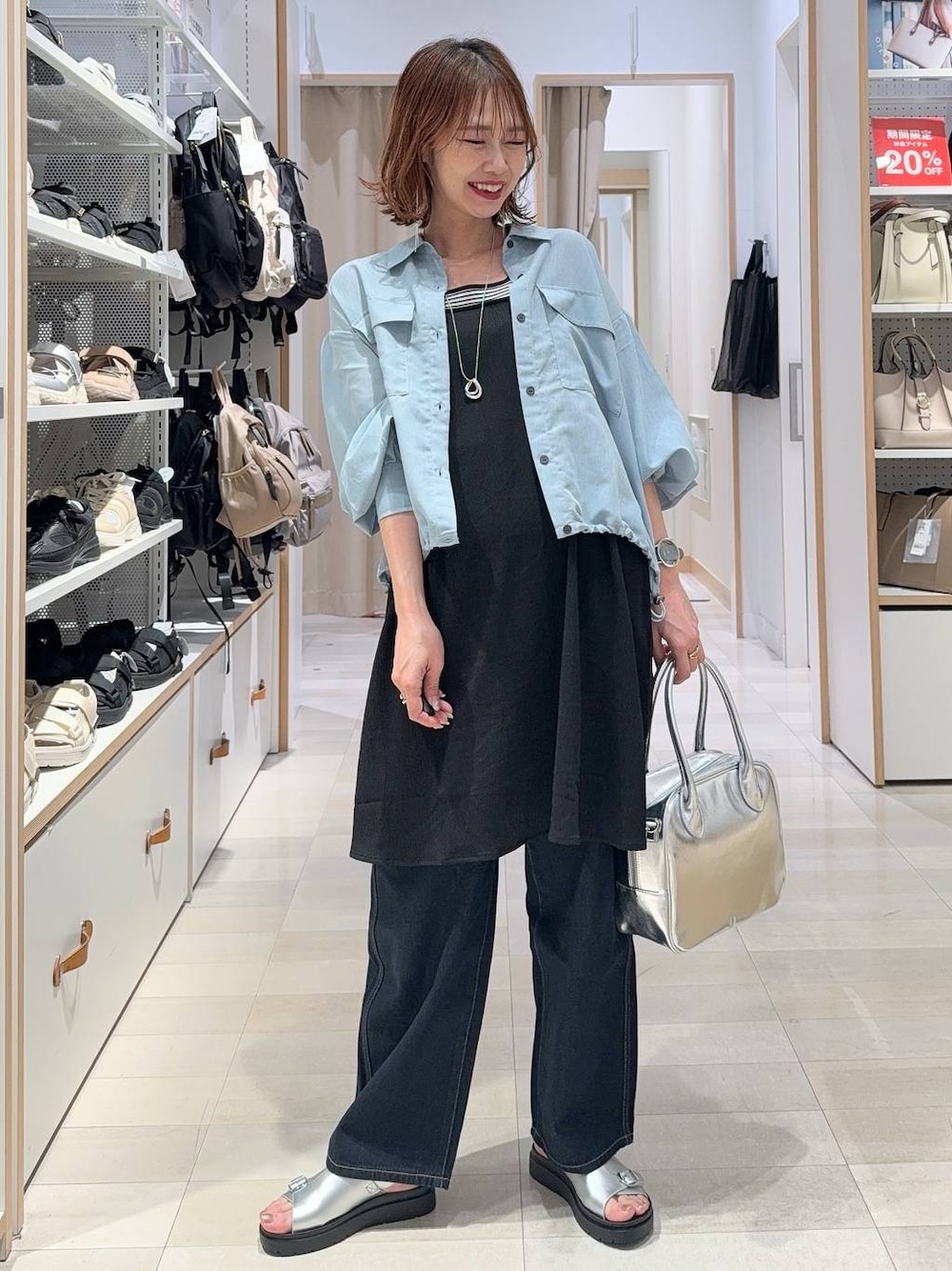 ブルー系のデニムパンツ、グレー系のボストンバッグ、ブルー系のシャツ/ブラウスを着用したレディースの春コーディネートの1枚目の写真