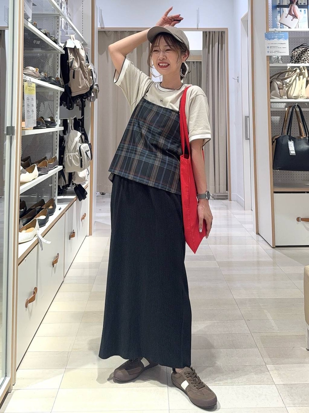 レッド系のトートバッグ、ブラック系のキャミソール、ブラック系のスカートを着用したレディースの夏コーディネートの1枚目の写真