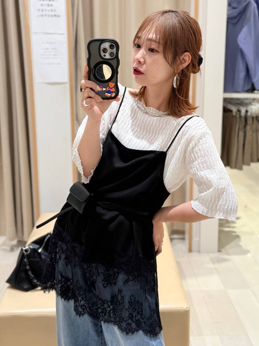 ブルー系のデニムパンツ、ブラック系のキャミソール、ブルー系のカーディガン/ボレロを着用したレディースの春コーディネートの1枚目の写真