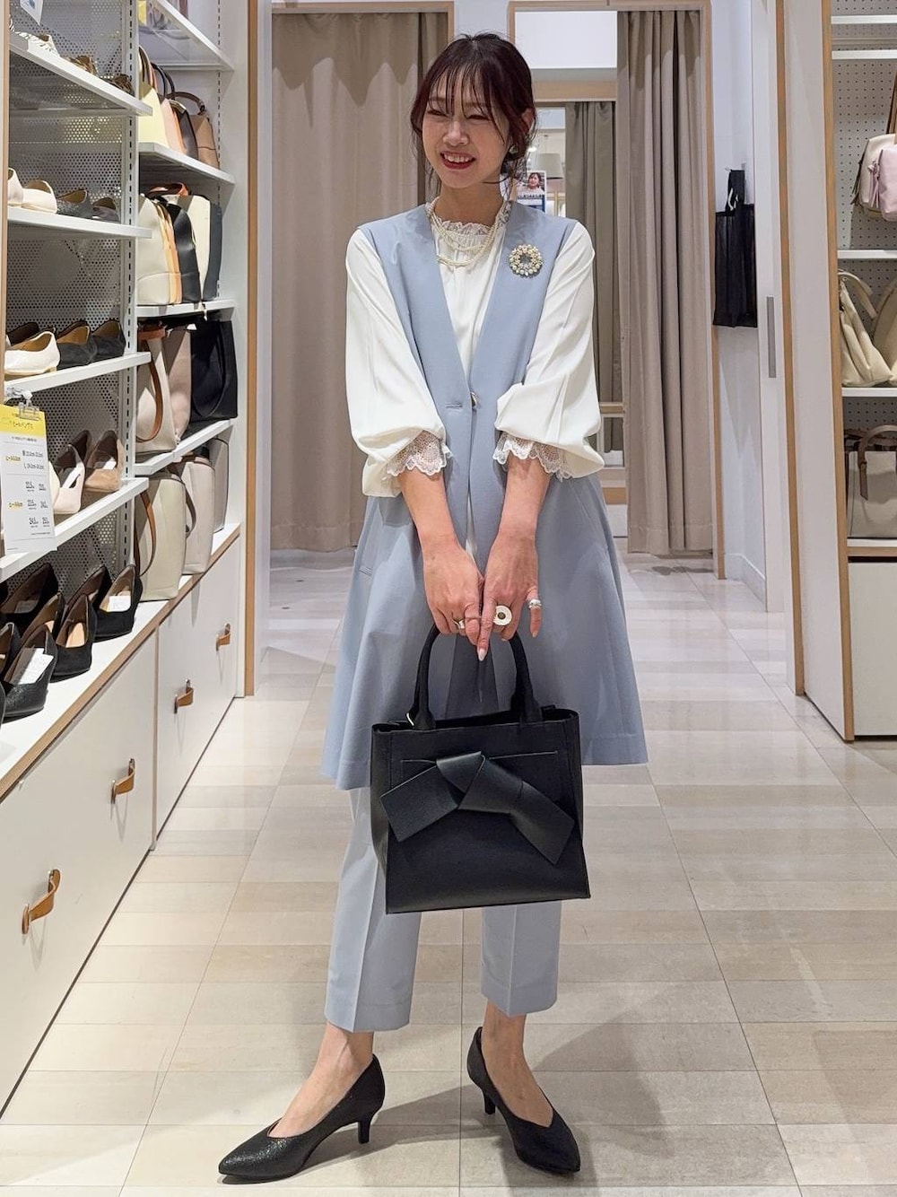 ブラック系のパンプス、ホワイト系のシャツ/ブラウス、ブルー系のスラックスを着用したレディースの冬コーディネートの1枚目の写真