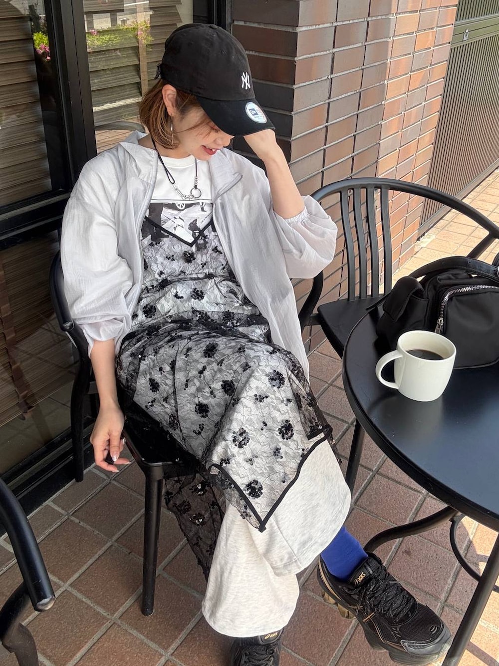 ブラック系のショルダーバッグ、ホワイト系のTシャツ/カットソー、ブラック系のワンピースを着用したレディースの春コーディネートの1枚目の写真