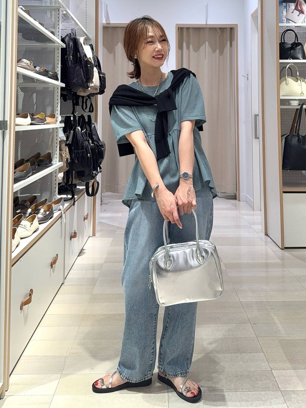ブルー系のデニムパンツ、グレー系のボストンバッグ、ブラック系のカーディガン/ボレロを着用したレディースの夏コーディネートの1枚目の写真