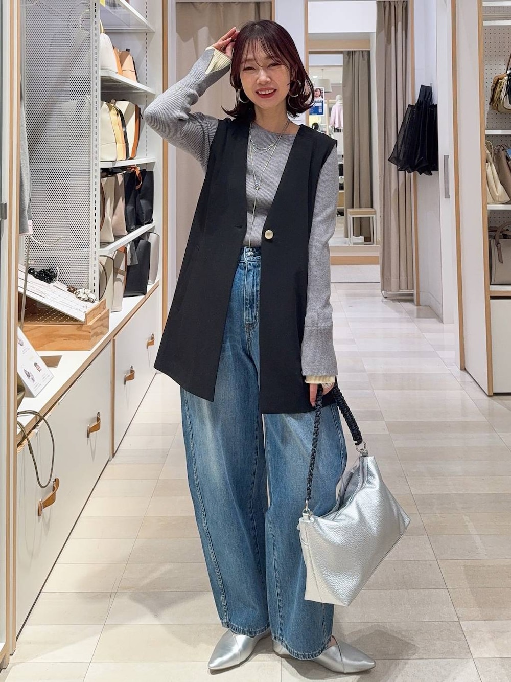 シルバー系のパンプス、ブラック系のその他アウター、ブルー系のデニムパンツを着用したレディースの冬コーディネートの1枚目の写真