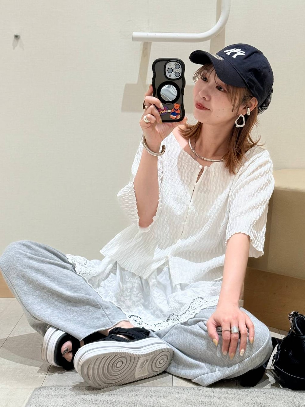 ホワイト系のキャミソール、グレー系のスウェットパンツ、ホワイト系のその他トップスを着用したレディースの春コーディネートの1枚目の写真