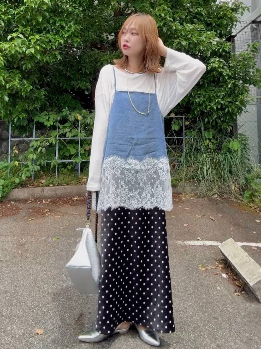 シルバー系のパンプス、ブラック系のスカート、ホワイト系のTシャツ/カットソーを着用したレディースの春コーディネートの1枚目の写真