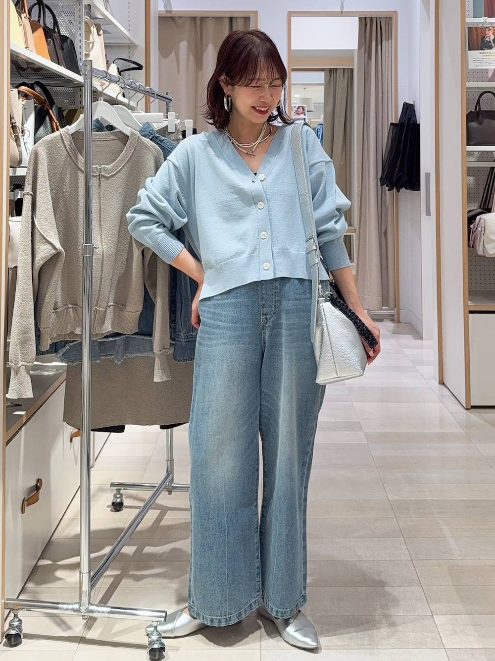 シルバー系のパンプス、ブラック系のキャミソール、ブルー系のデニムパンツを着用したレディースの冬コーディネートの1枚目の写真