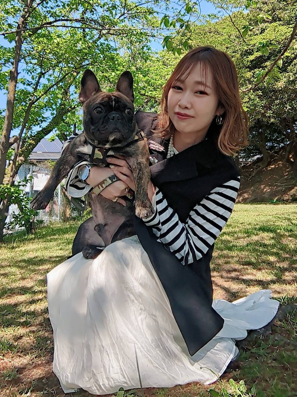 ブルー系のTシャツ/カットソー、ホワイト系のスカート、ブラック系のベストを着用したレディースの春コーディネートの1枚目の写真