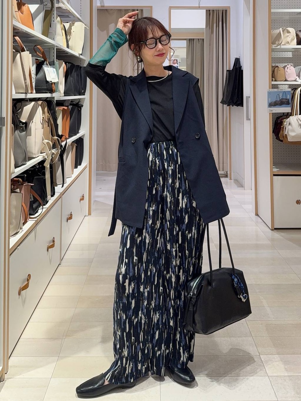 ブラック系のその他シューズ、ブラック系のボストンバッグ、ブルー系のベストを着用したレディースの春コーディネートの1枚目の写真