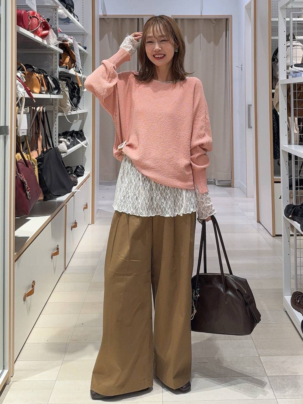 ピンク系のニット/セーター、ブラウン系のローファー、ブラウン系のボストンバッグを着用したレディースの秋コーディネートの1枚目の写真