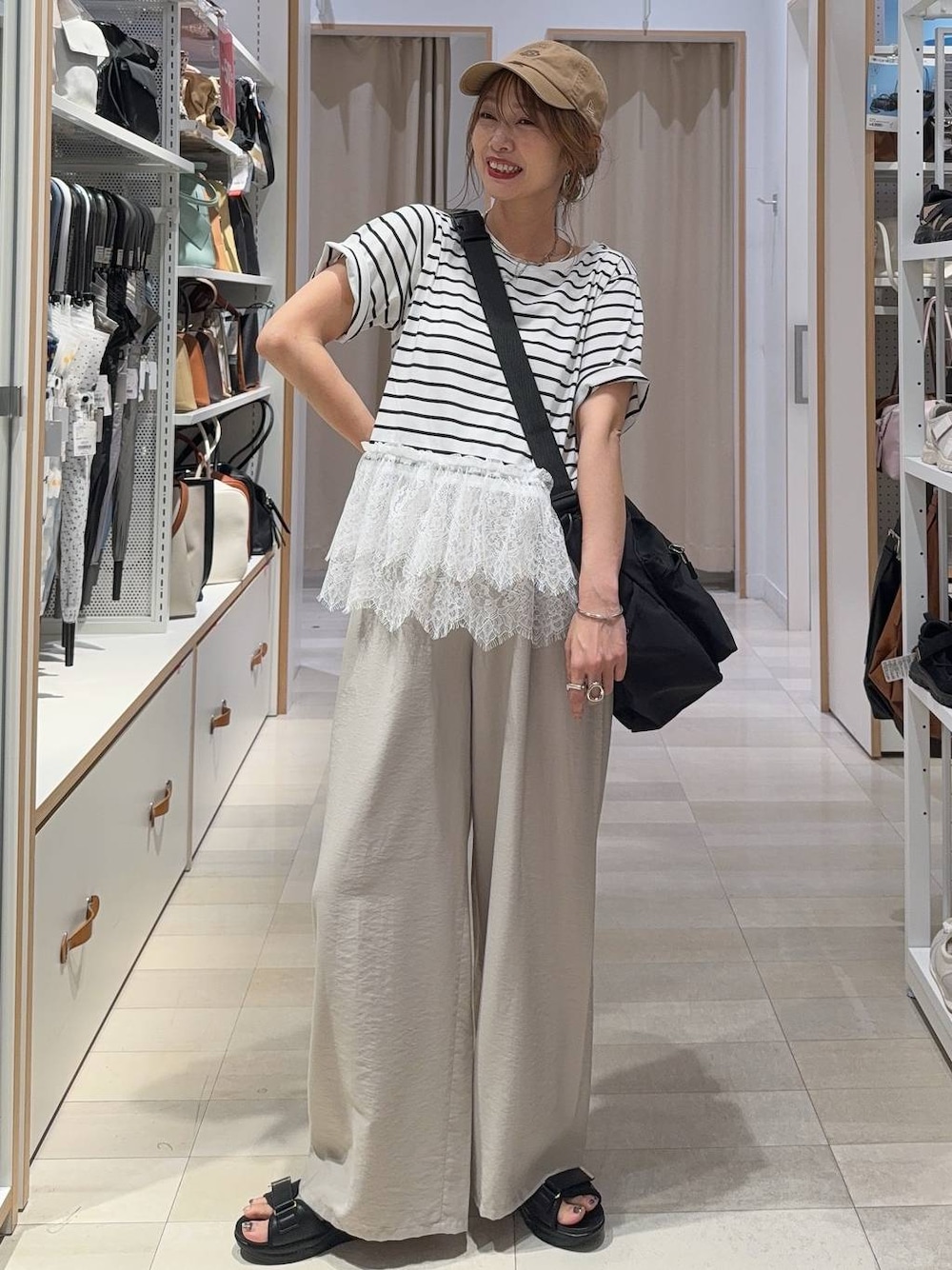 ブラック系のショルダーバッグ、ベージュ系のその他パンツ、ブラック系のサンダルを着用したレディースの夏コーディネートの1枚目の写真
