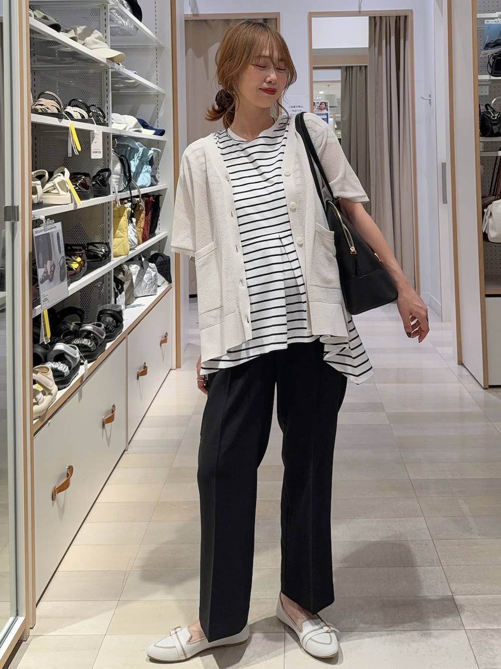ホワイト系のパンプス、ブラック系のボストンバッグ、ブラック系のその他パンツを着用したレディースの夏コーディネートの1枚目の写真