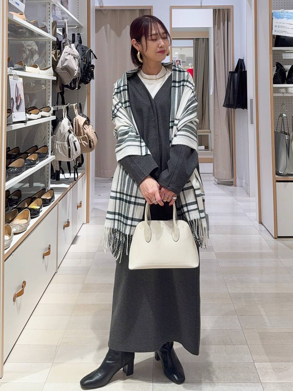 ホワイト系のショルダーバッグ、ブラック系のブーツ、ブラウン系のバレッタ/ヘアクリップを着用したレディースの秋コーディネートの1枚目の写真