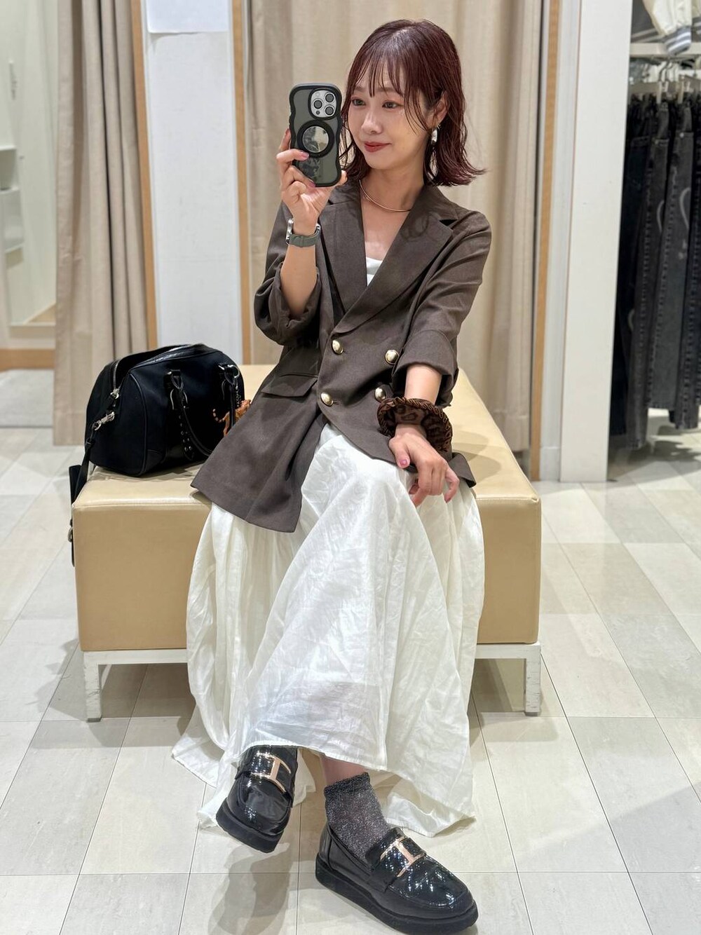 ブラック系のローファー、ホワイト系のキャミソール、ブラウン系のテーラードジャケットを着用したレディースの秋コーディネートの1枚目の写真