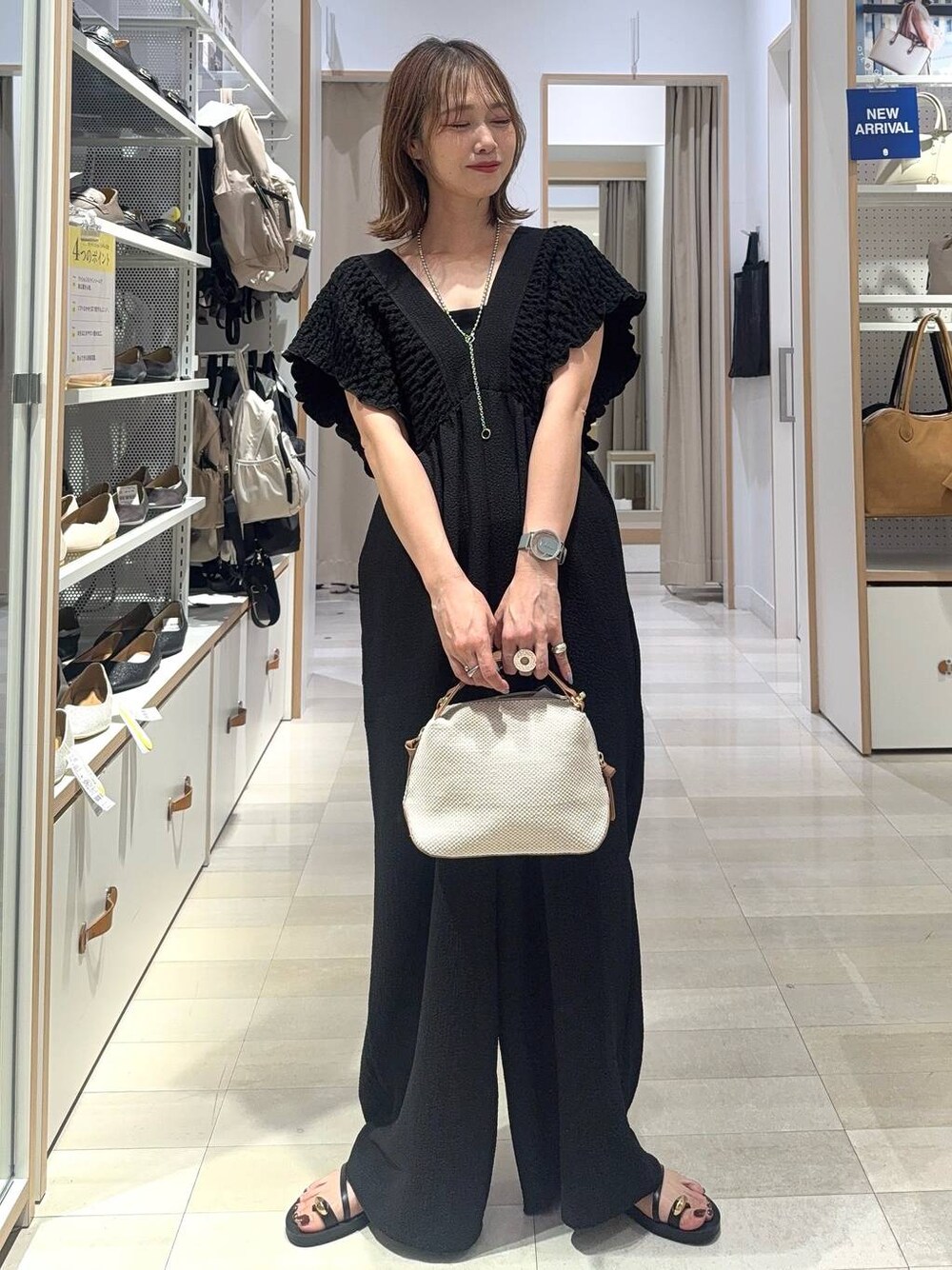 ホワイト系のショルダーバッグ、ブラック系のキャミソール、ブラック系のサンダルを着用したレディースの夏コーディネートの1枚目の写真