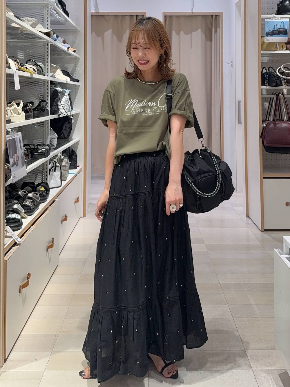 ブラック系のスカート、グリーン系のTシャツ/カットソー、グレー系のキャミソールを着用したレディースの夏コーディネートの1枚目の写真