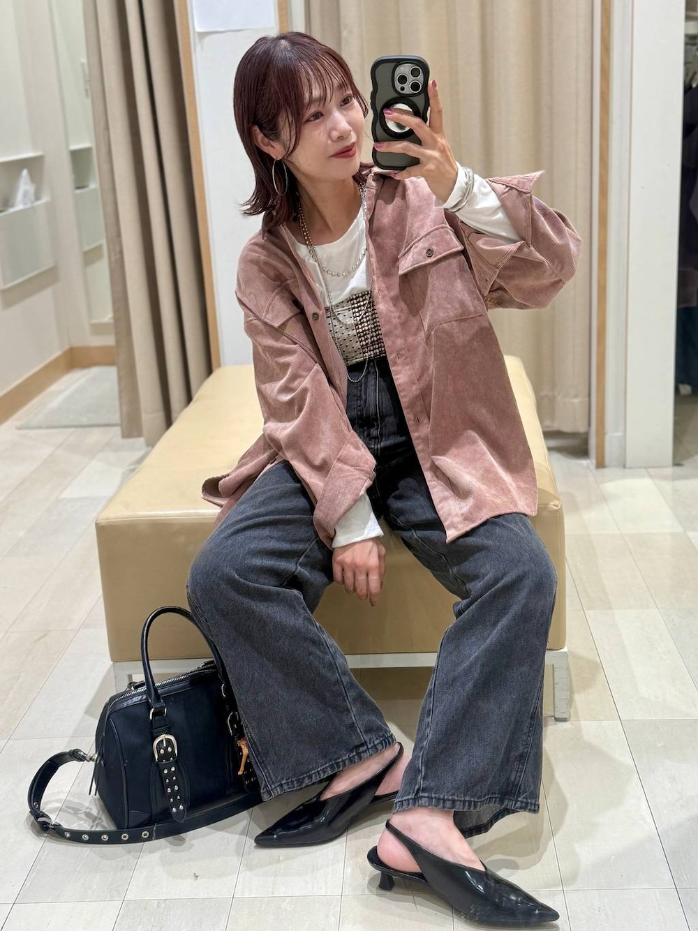 ピンク系のシャツ/ブラウス、ブラック系のボストンバッグ、ブラウン系のベストを着用したレディースの秋コーディネートの1枚目の写真