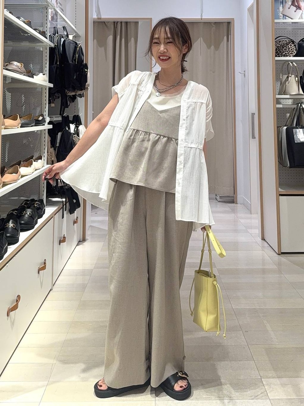 ホワイト系のタンクトップ、イエロー系のショルダーバッグ、ホワイト系のシャツ/ブラウスを着用したレディースの夏コーディネートの1枚目の写真