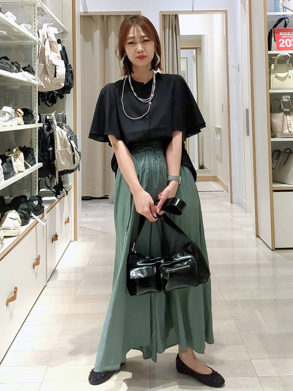 ブラック系のバレエシューズ、ブラック系のショルダーバッグ、ブラック系のシャツ/ブラウスを着用したレディースの春コーディネートの1枚目の写真