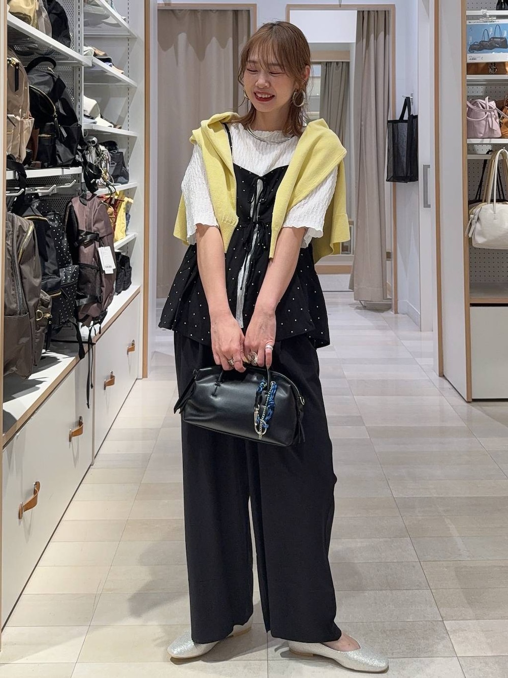 ベージュ系のパンプス、イエロー系のカーディガン/ボレロ、ブラック系のその他パンツを着用したレディースの春コーディネートの1枚目の写真