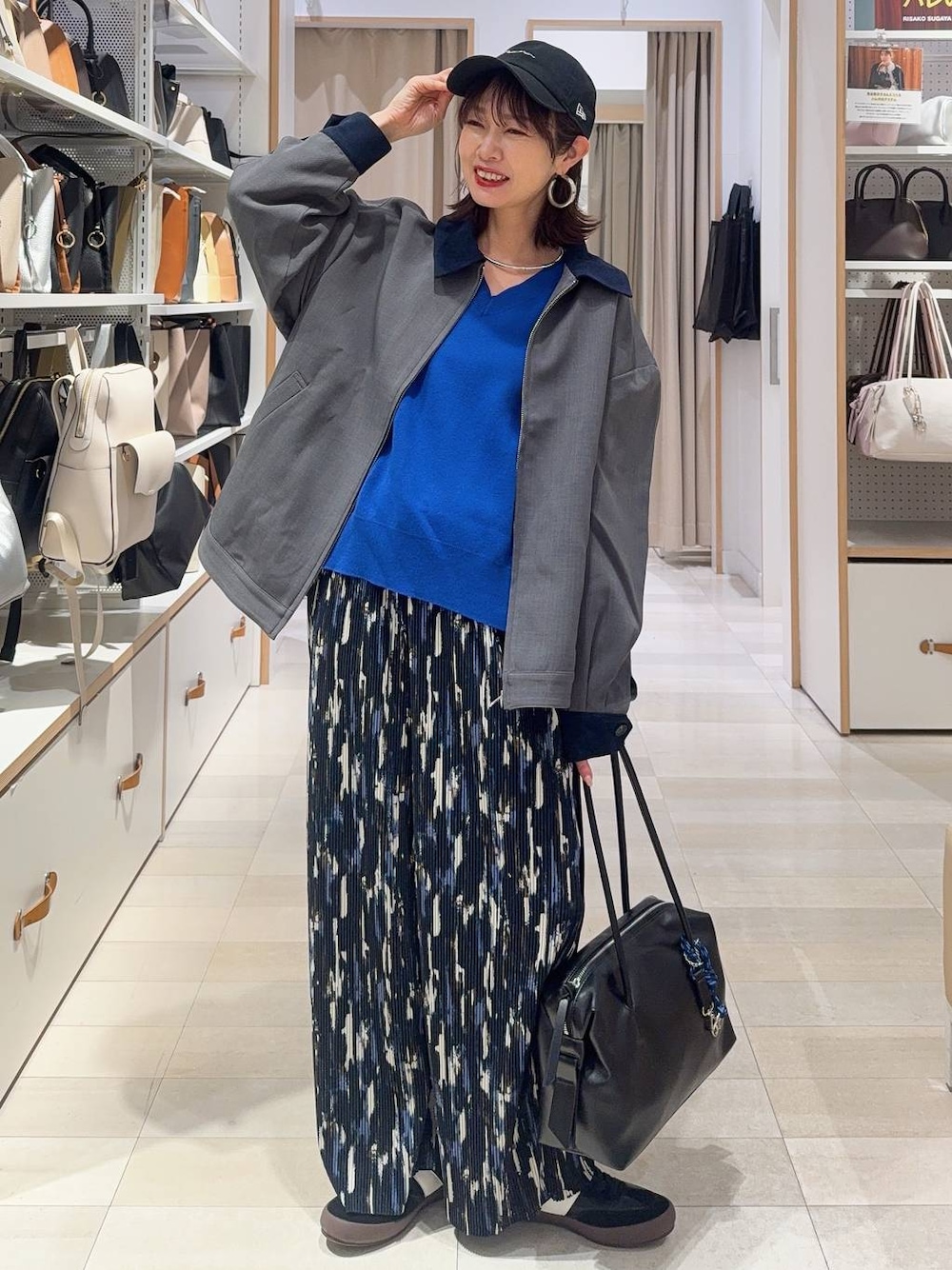 ブラック系のスニーカー、ブラック系のボストンバッグ、ブルー系のニット/セーターを着用したレディースの冬コーディネートの1枚目の写真