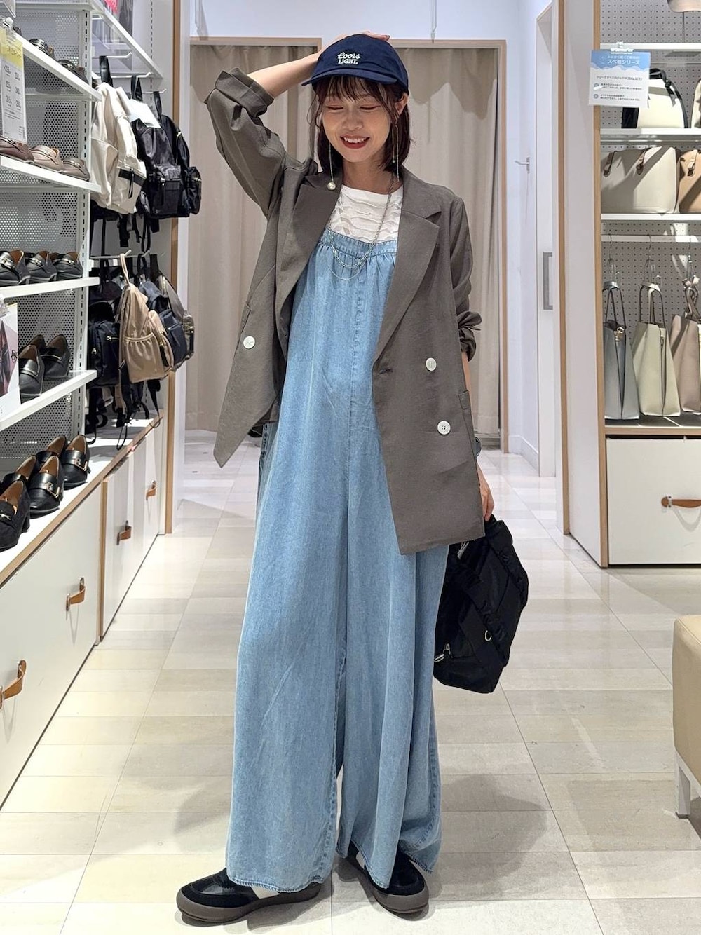 ブラック系のスニーカー、ブラック系のショルダーバッグ、ホワイト系のTシャツ/カットソーを着用したレディースの秋コーディネートの1枚目の写真