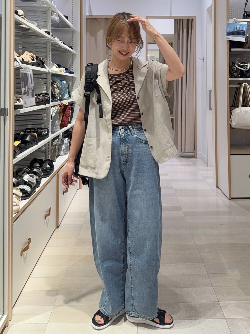 ブルー系のデニムパンツ、ブラウン系のタンクトップ、ベージュ系のシャツ/ブラウスを着用したレディースの夏コーディネートの1枚目の写真