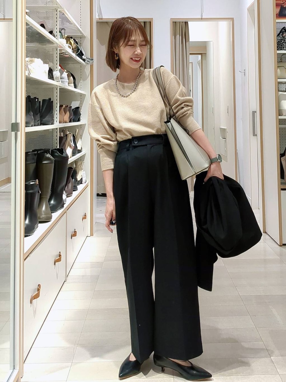 シルバー系のトートバッグ、ベージュ系のニット/セーター、ブラック系のその他パンツを着用したレディースの春コーディネートの1枚目の写真