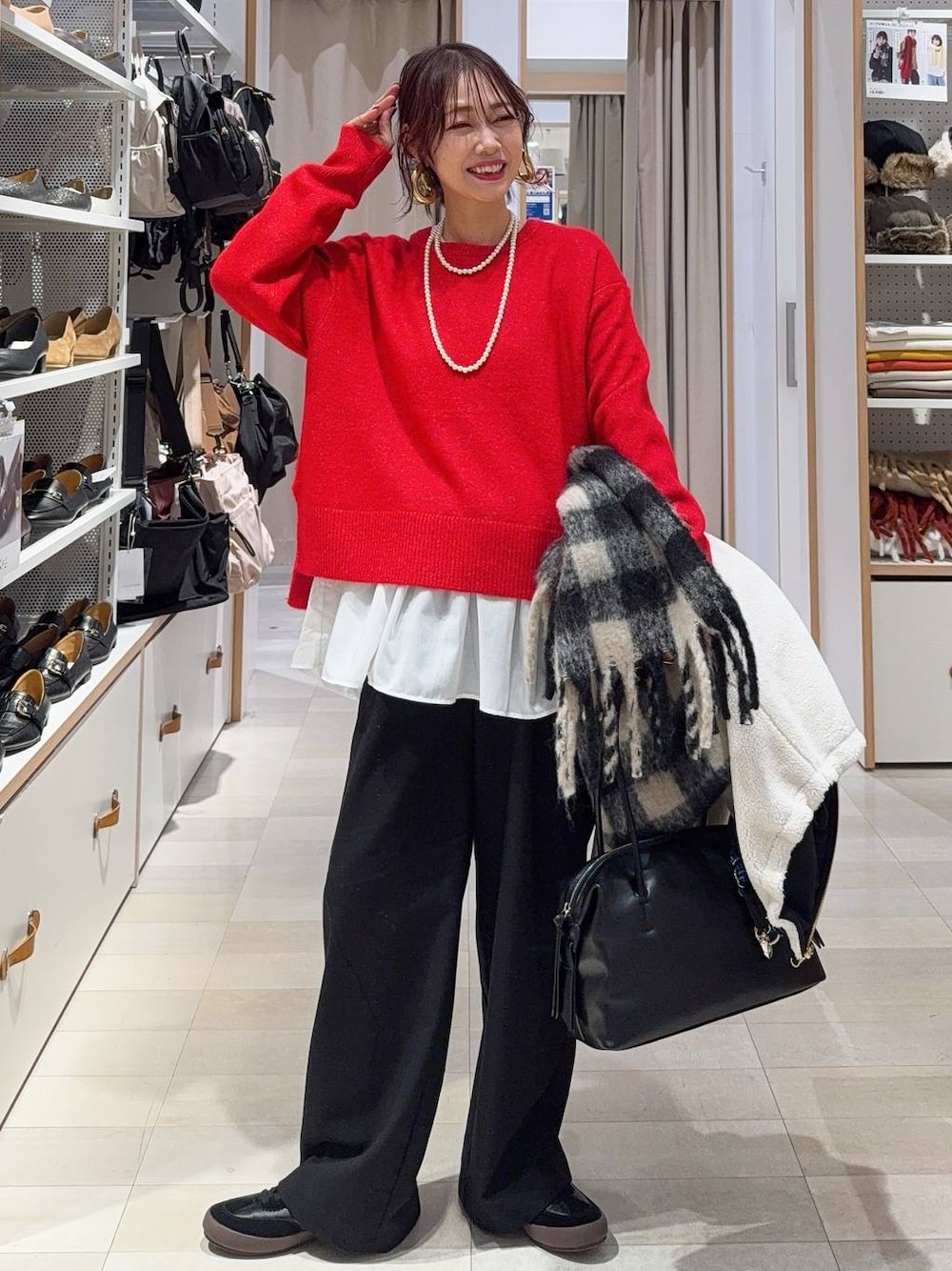 ブラック系のスニーカー、ブラウン系のボストンバッグ、ホワイト系のブルゾンを着用したレディースの冬コーディネートの1枚目の写真