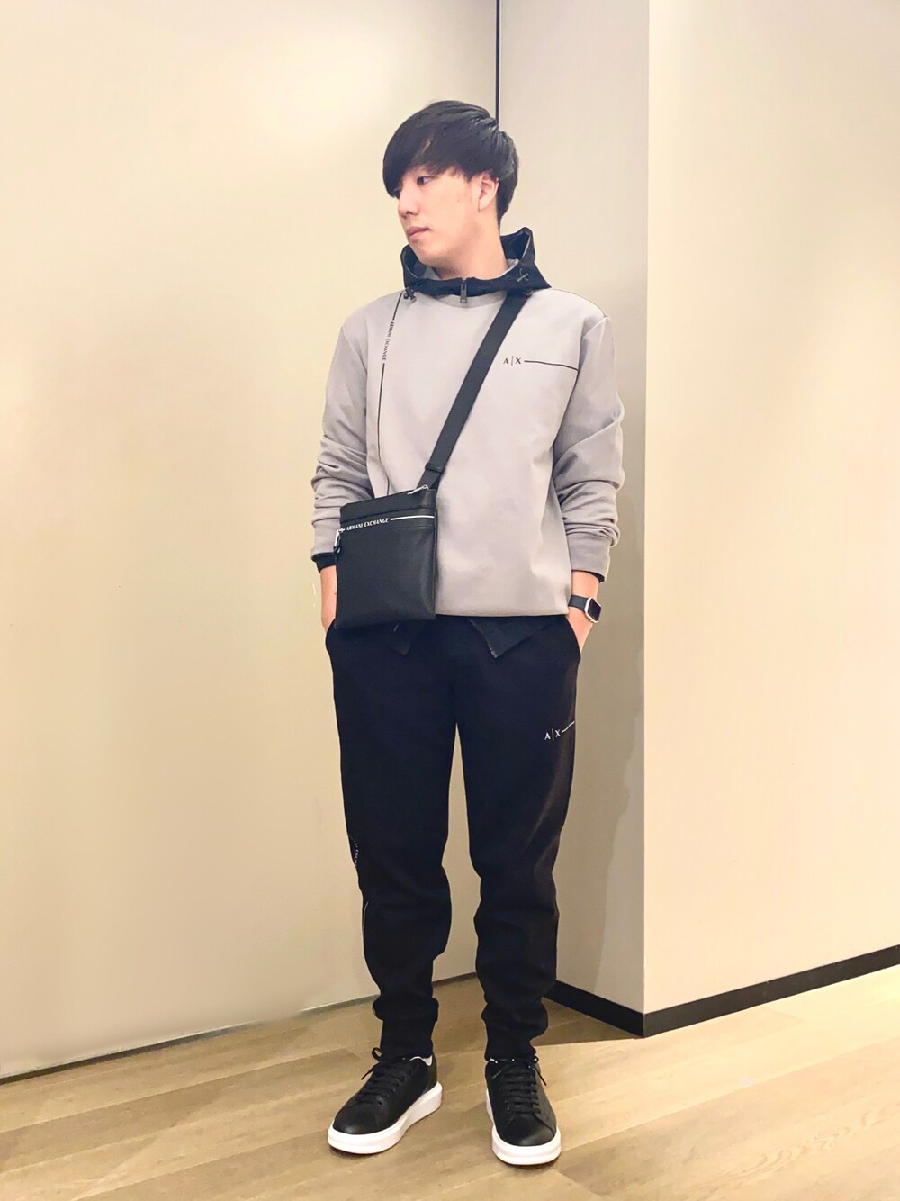 「armaniexchange、アルマーニエクスチェンジ、AXchanger、AXchange、スウェット、ナイロンジャケット、スウェットパンツ、ショルダーバッグ、スニーカー、レザー、モノトーン、シンフルコーデ、きれいめカジュアル」｜「ARMANI EXCHANGEの【A|X アルマーニ エクスチェンジ】ロゴライン　スウェットプルオーバー（スウェット、グレー系）」を使った、yusukeさん（メンズ・175cm）の冬コーディネートの1枚目の写真
