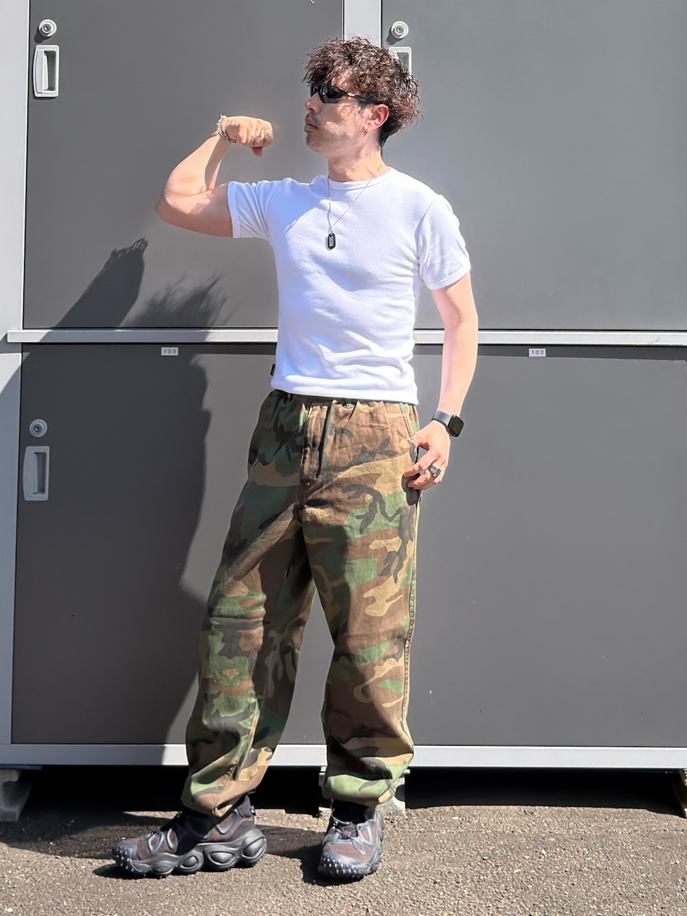 ホワイト系のTシャツ/カットソー、グリーン系のその他パンツ、ブラック系のスニーカーを着用したメンズの秋コーディネートの1枚目の写真