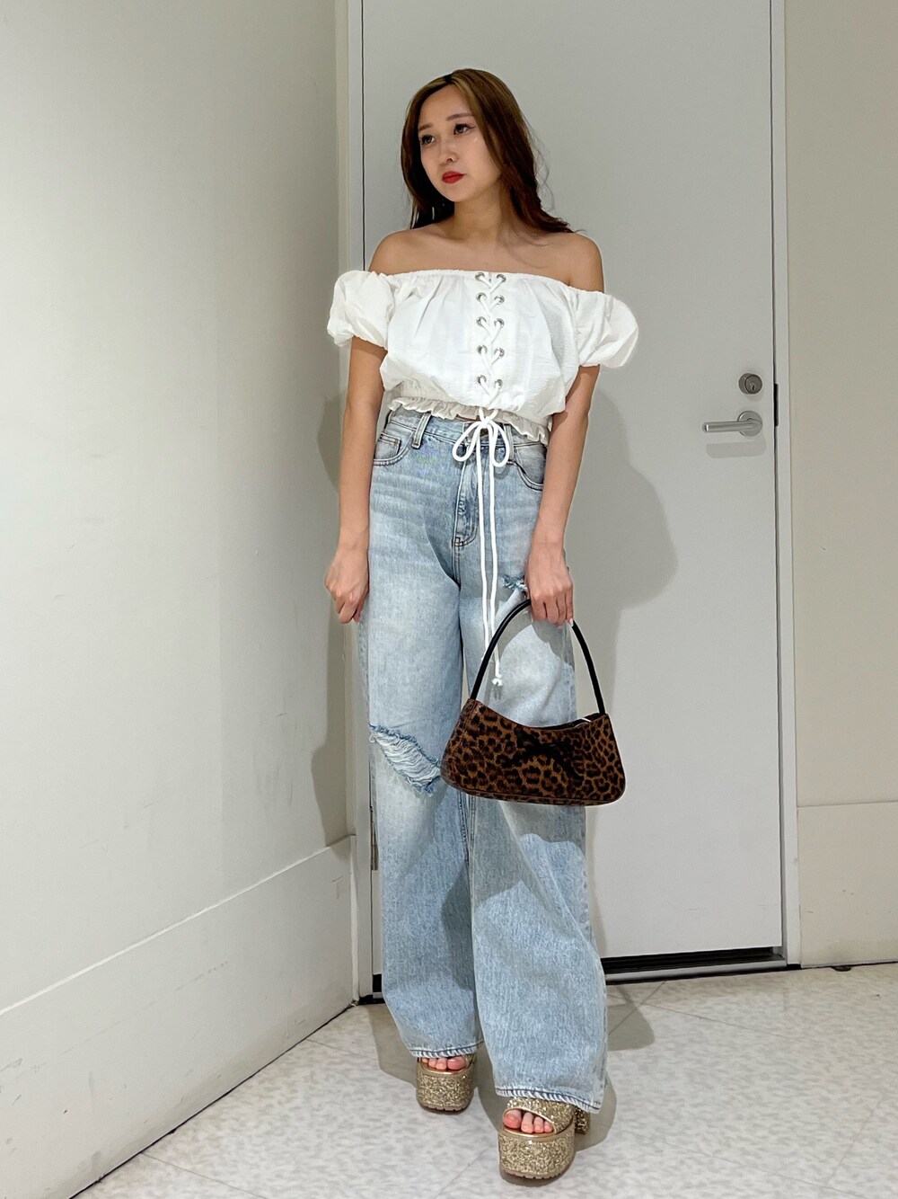 ホワイト系のシャツ/ブラウス、ブルー系のデニムパンツ、ブラウン系のハンドバッグを着用したレディースの夏コーディネートの1枚目の写真